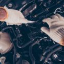 An overhead view of a mechanic working on a car engine