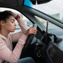 A person sitting in a car on a warm day