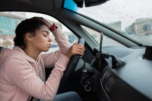 A person sitting in a car on a warm day