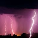 Lightnings and storm over forest at night.