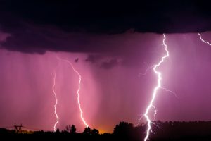 Lightnings and storm over forest at night.